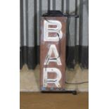 A green neon 'Bar' light,