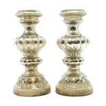 A pair of silvered glass candle stands,