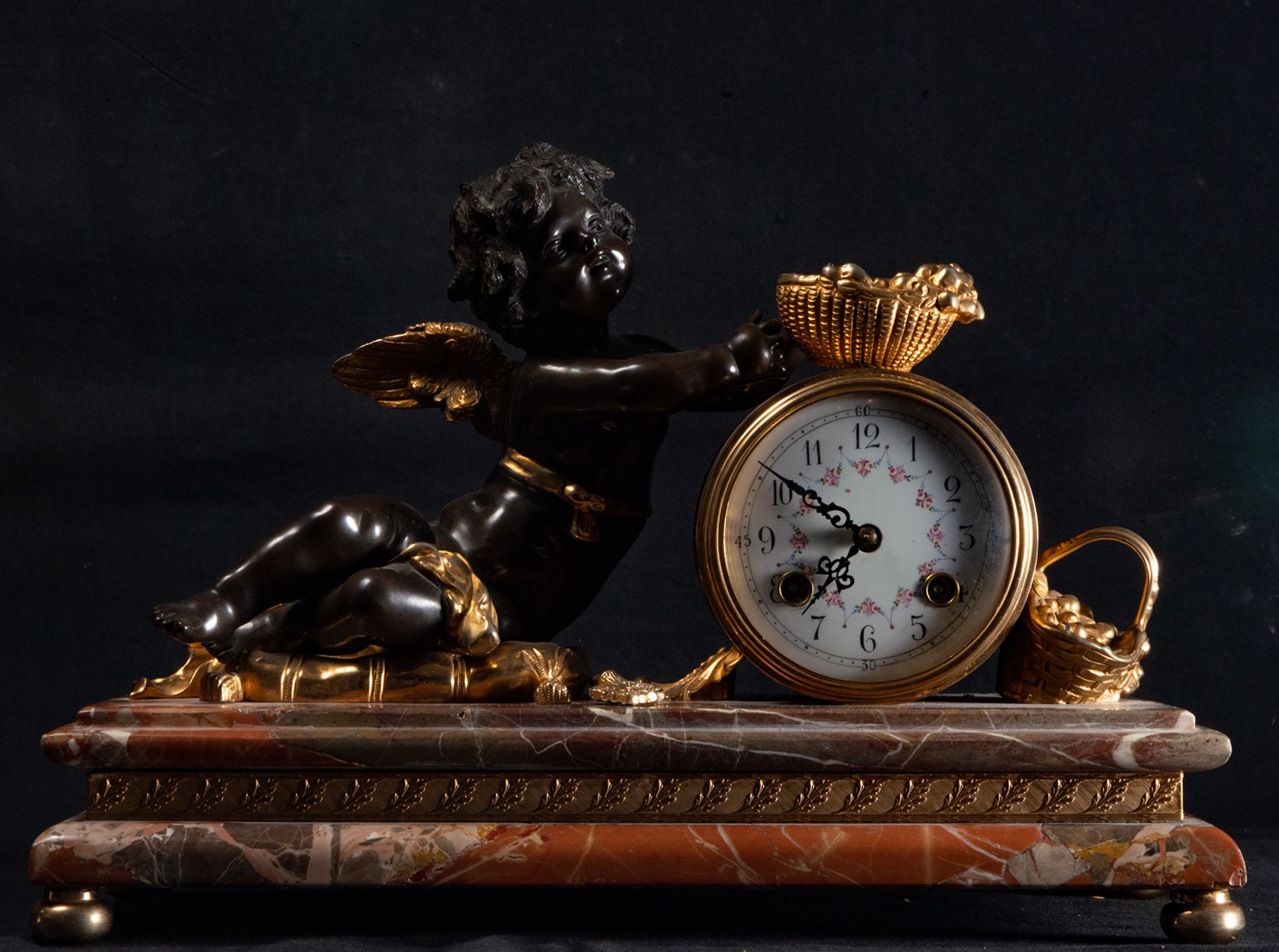 Elegant table clock with Cupid in gilt and patinated bronze on a red marble base, 19th century
