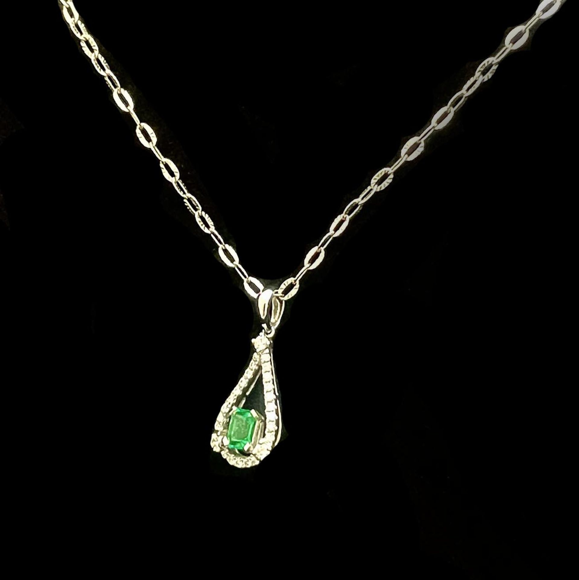 18kt white gold teardrop pendant, diamonds and emerald.