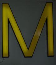 Illuminated poster with the letter "M", appearing in the painting "Gran Vía" by Antonio López