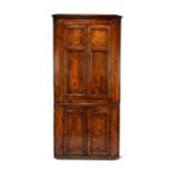 A George III elm and oak floor standing corner cupboard