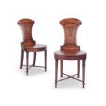 A pair of late George IV / Regency mahogany hall chairs