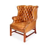 A George III style tan leather buttoned wing armchair