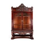 An impressive late Victorian carved mahogany serpentine display cabinet possibly by Gillows