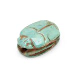 An Egyptian green glazed faience amulet bead in the form of scarab beetle