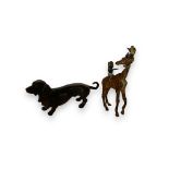 An early 20th century bronze figure of a Dachshund and a Bergman style cold painted figure of boys r