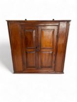 A 19th century mahogany hanging corner cupboard With double panelled doors enclosing a shelf, 65cm