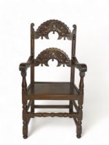 A 17th century style carved oak Derbyshire open armchair With carved horizontal splats, open arms