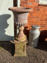 A pair of vintage terracotta urns on pedestals