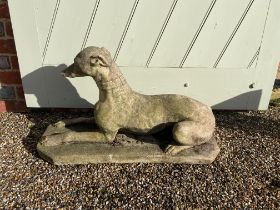 A vintage composition stone model of a recumbent greyhound