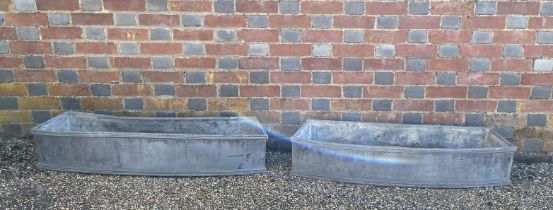 A pair of narrow rectangular lead trough planters of slight bowed form