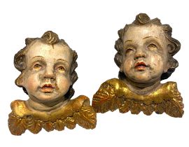 A pair of 19th century Italian polychrome and parcel gilt amorini heads