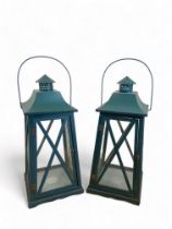 A pair of large green painted garden lanterns