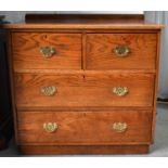 An antique elm chest of drawers, two deep over two long drawers with brass fittings, circa 1920,