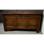 A 17th century oak coffer, with two panel lid, and two carved panels to the front, candle box