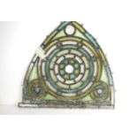 An antique stained glass window in different shades of green, measuring 60cm by 55cm.