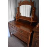 A mahogany Edwardian dressing table with mirrored back and two short over one long drawer, raised on