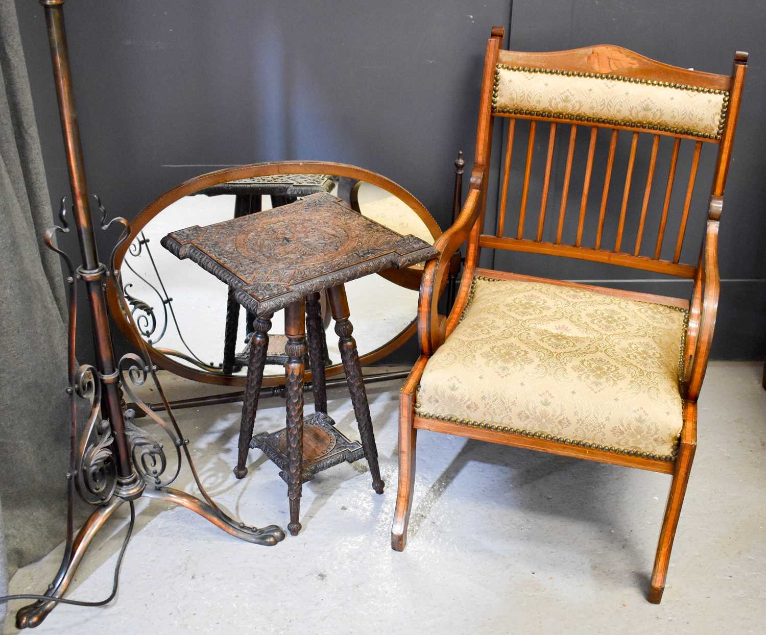 An Edwardian marquetry inlaid bedroom armchair, an oval toilet mirror, an Indian hardwood carved