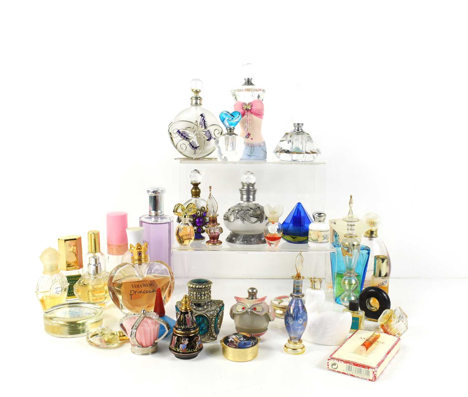 A group of glass scent bottles and some part-used perfumes to include Vera Wang and Yardley.