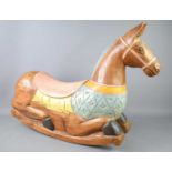 A carved and painted miniature wooden rocking horse, 55cm tall.