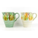 A pair of Clarice Cliff jugs, with floral decoration to both, one with pale green ground.