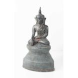 A bronze statue of the Buddha in Bhumisparsha Mudra pose, with serene face, sat cross legged on a