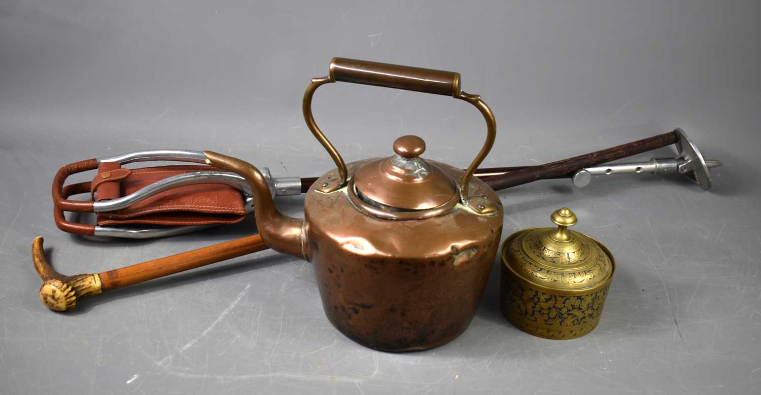 A copper kettle together with a shooting stick, horn handled walking cane and a brass lidded pot.