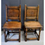 A pair of 17th century style hall chairs with panel back carved with floral lozenge.