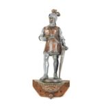 A vintage metalware wall-mounted knight with a sword and shield standing on an ornate metal base