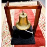 A large antique brass ships bell raised on a later stand, the bell circa 1900, the stand 76cm high.