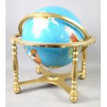 A world globe inset with various semi precious stones on a brass stand with compass, 45cm high.