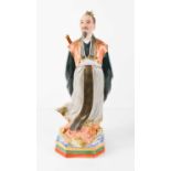 A porcelain figure of a Japanese nobleman, with finely painted bisque face, wearing flowing robes,