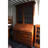 A 19th Century mahogany bureau bookcase, the bookcase with glazed doors enclosing three adjustable