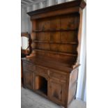 An oak dresser and rack in the 19th century style, the rack having three shelves, the base with