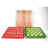 A vintage Greek Manopoulos chess set in a wooden box, comprising a green and gold coloured board and