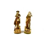 A pair of early 20th century Royal Dux figures of a shepherd and shepherdess, he playing a pipe, and