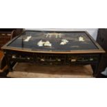 A modern black lacquered Chinese style low table, the top depicting a temple with female figure to