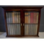 A small 19th century cabinet with glazed doors enclosing dummy books, single interior shelf, 85 by