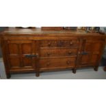 An Owl Man oak dining suite, comprising a refectory table, with three plank top on two ovatgonal