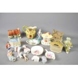 A group of ceramic cottages and money boxes, along with candle sticks, etc.