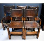 A set of five oak and leather clad dining chairs, with brass studs.