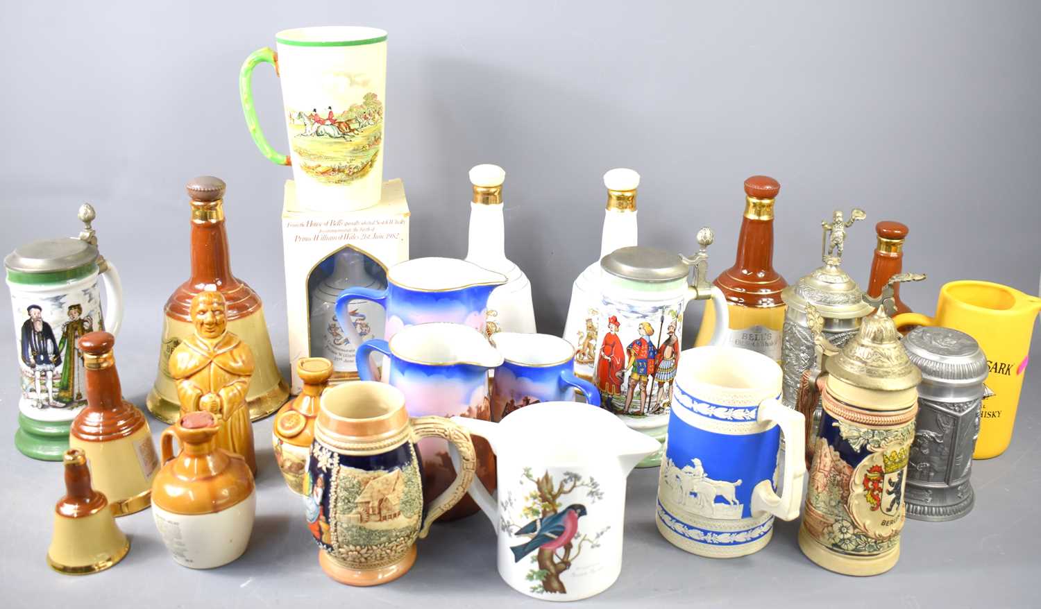 A group of Bells whisky decanters together with various tankards and jugs to include Portmeirion,