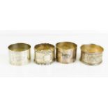 A collection of four silver napkin rings, two hallmarked London, and a pair for Birmingham 1917.