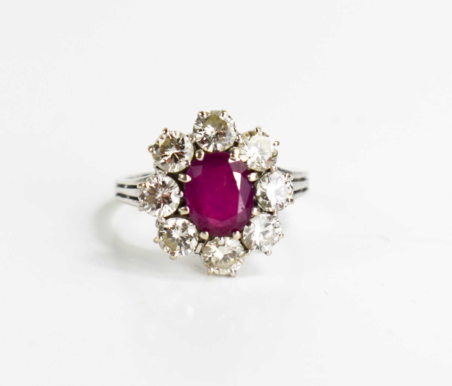 An 18ct white gold, (unmarked but tested as 18ct) ruby and diamond flowerhead ring, the central oval - Image 9 of 11