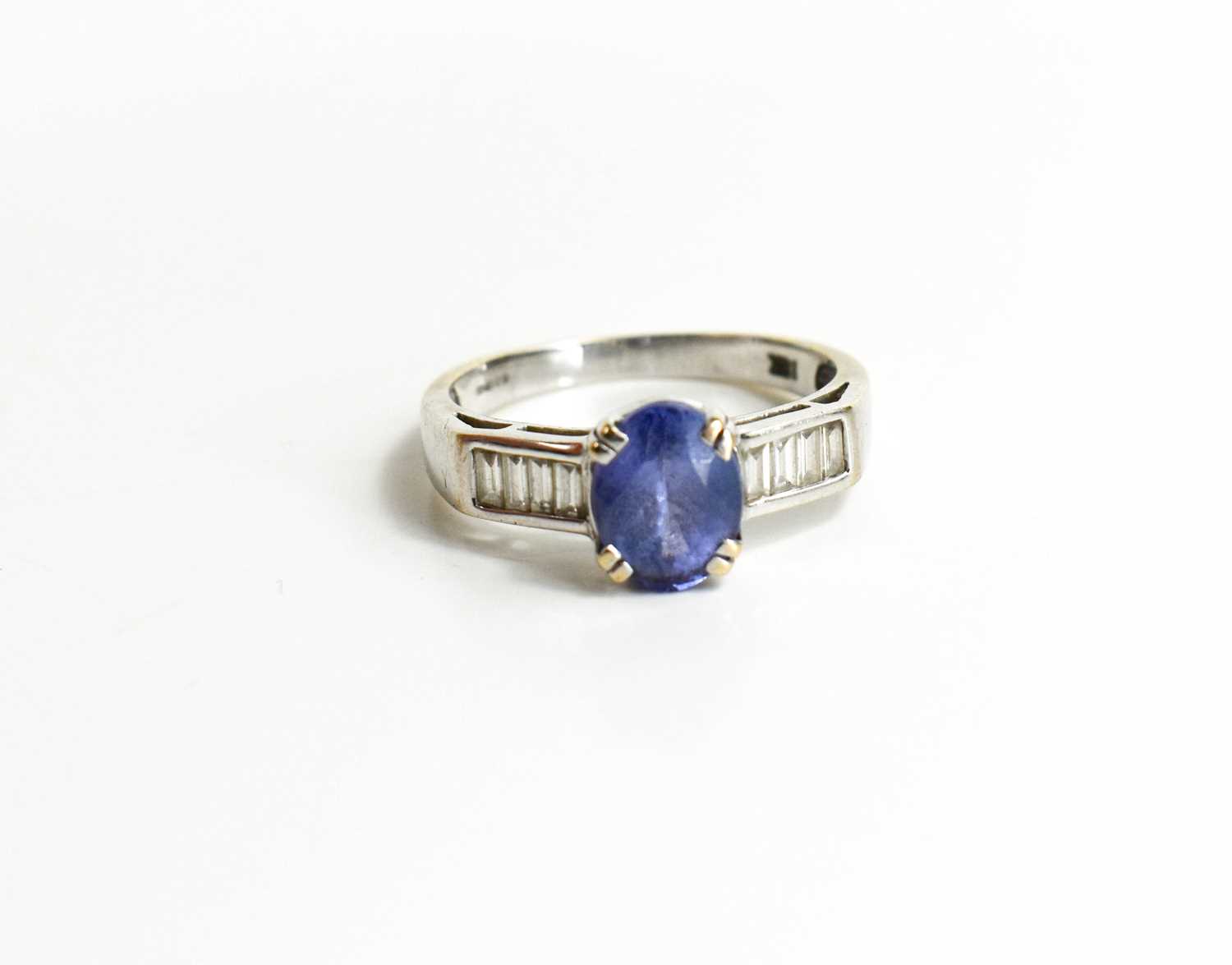 An 18ct white gold, tanzanite and diamond ring, the oval cut tanzanite flanked by baguette cut - Image 2 of 4