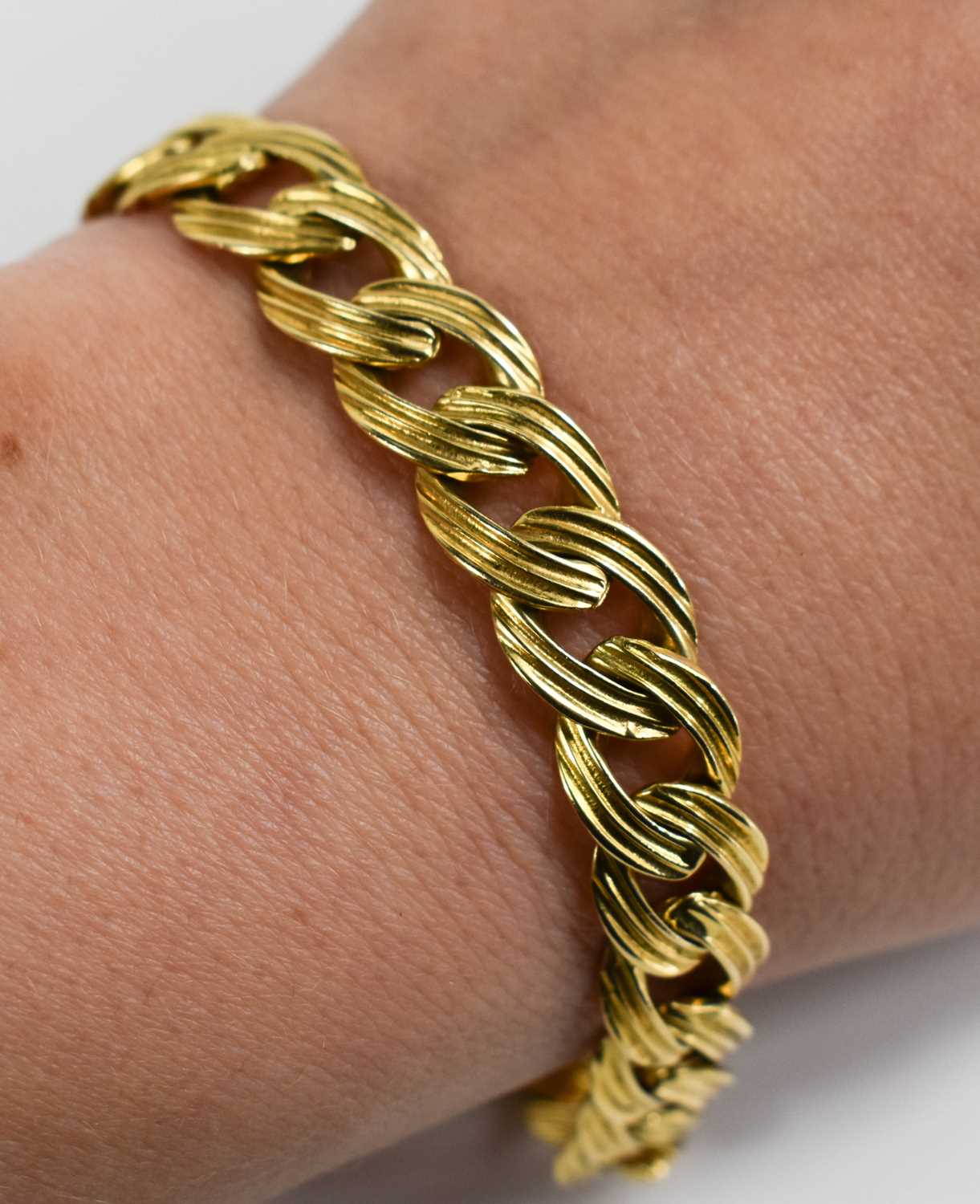 An 18ct gold flat curb link bracelet with reeded detail, 21cm long, 32.93g. - Image 2 of 2