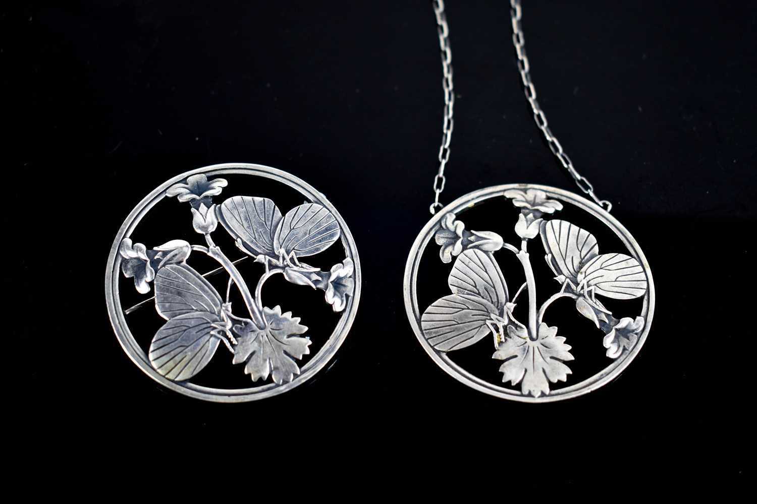 A Georg Jensen silver pendant necklace and matching brooch, both of circular form pierced to