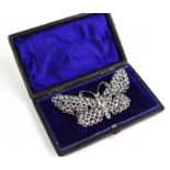 A vintage silvered metal and paste set butterfly form brooch, 8 by 4.5cm, in an antique presentation