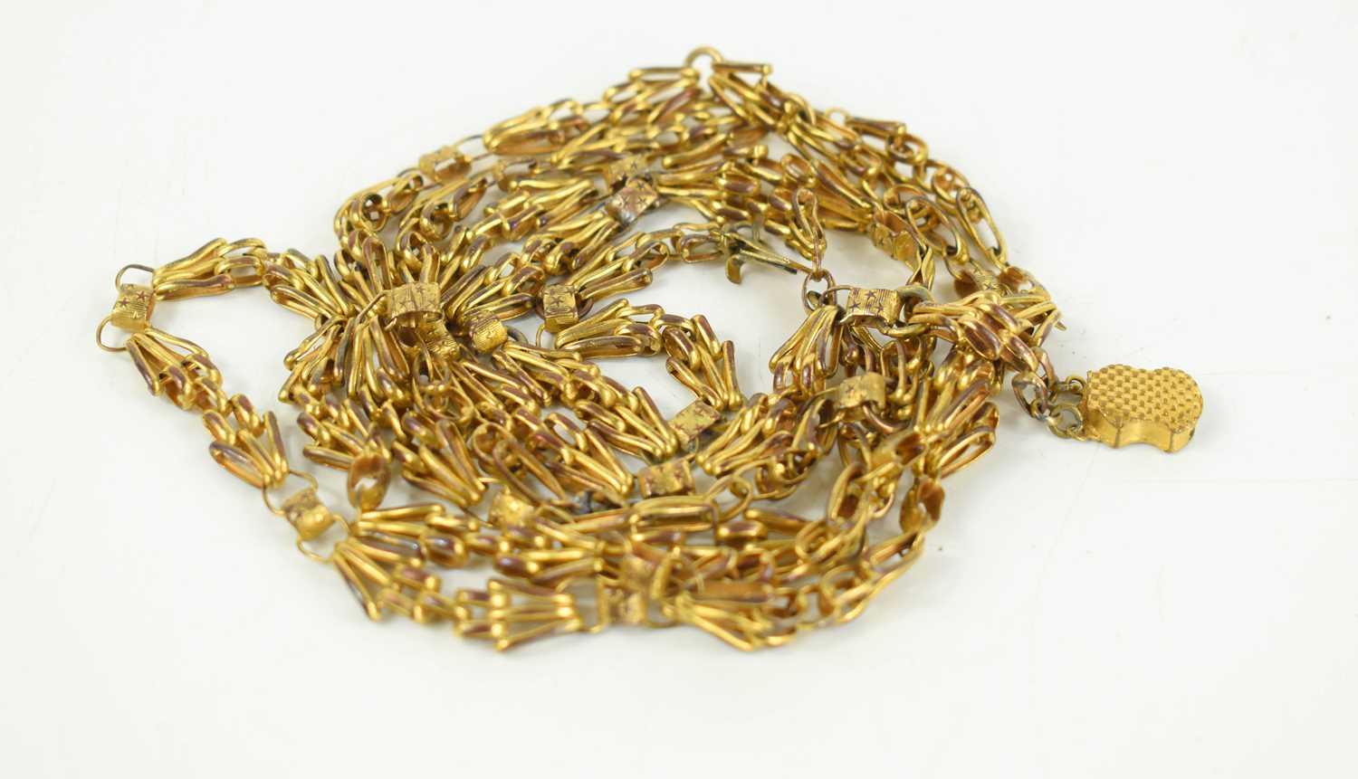 A gilt metal guard chain of intricate fancy links with cartouche clasp, 132cm long.